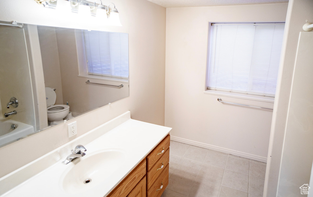 Full bathroom featuring vanity, tile patterned flooring, toilet, and baseboards