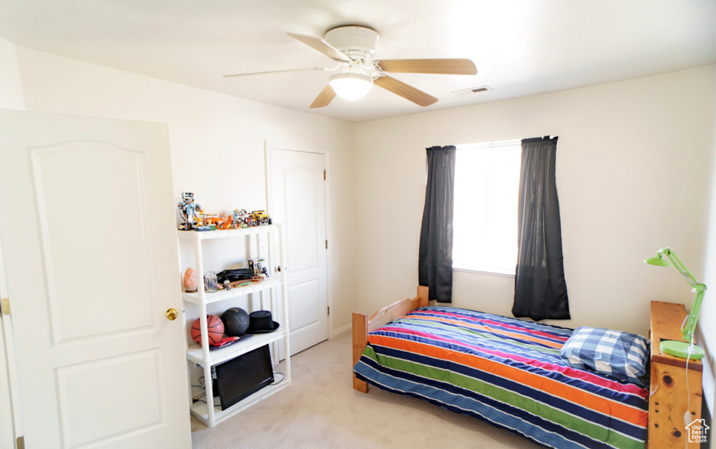 Carpeted bedroom with ceiling fan