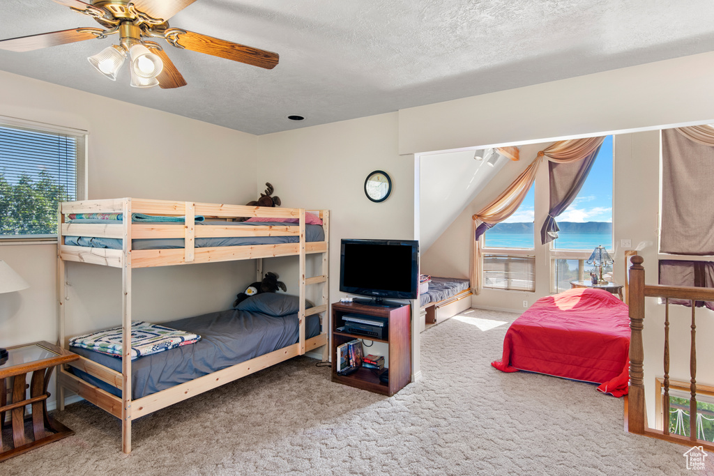 Bedroom featuring carpet flooring, a textured ceiling, and ceiling fan