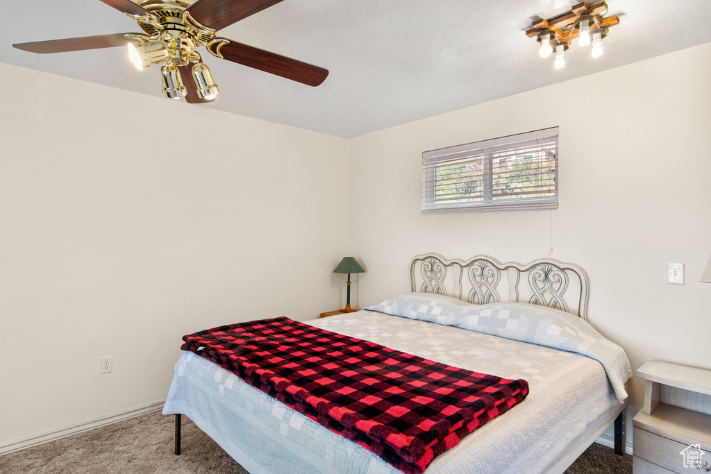 Carpeted bedroom with a ceiling fan