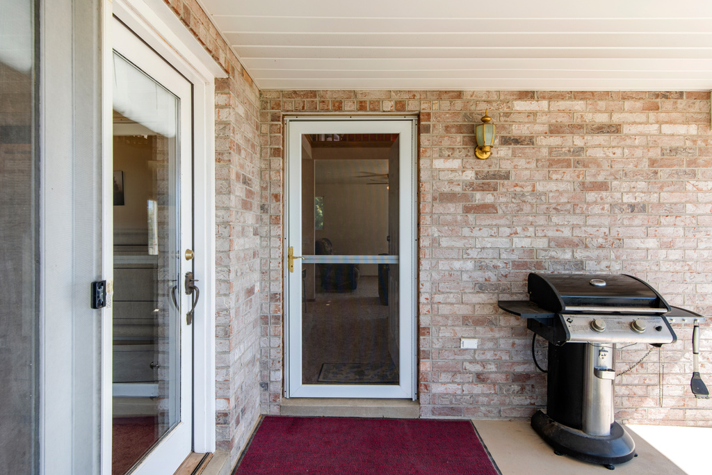 Doorway to property with brick siding