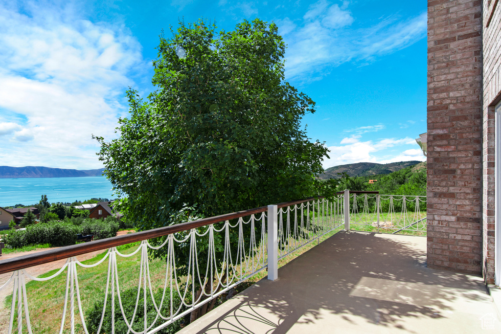 Balcony featuring a water and mountain view