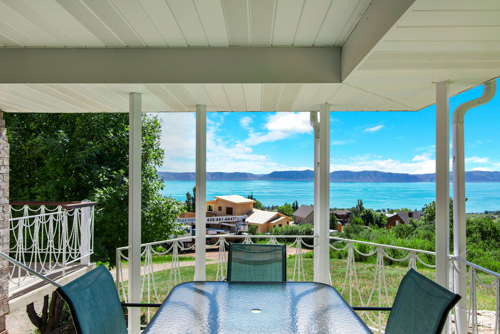Balcony featuring a water and mountain view and outdoor dining area
