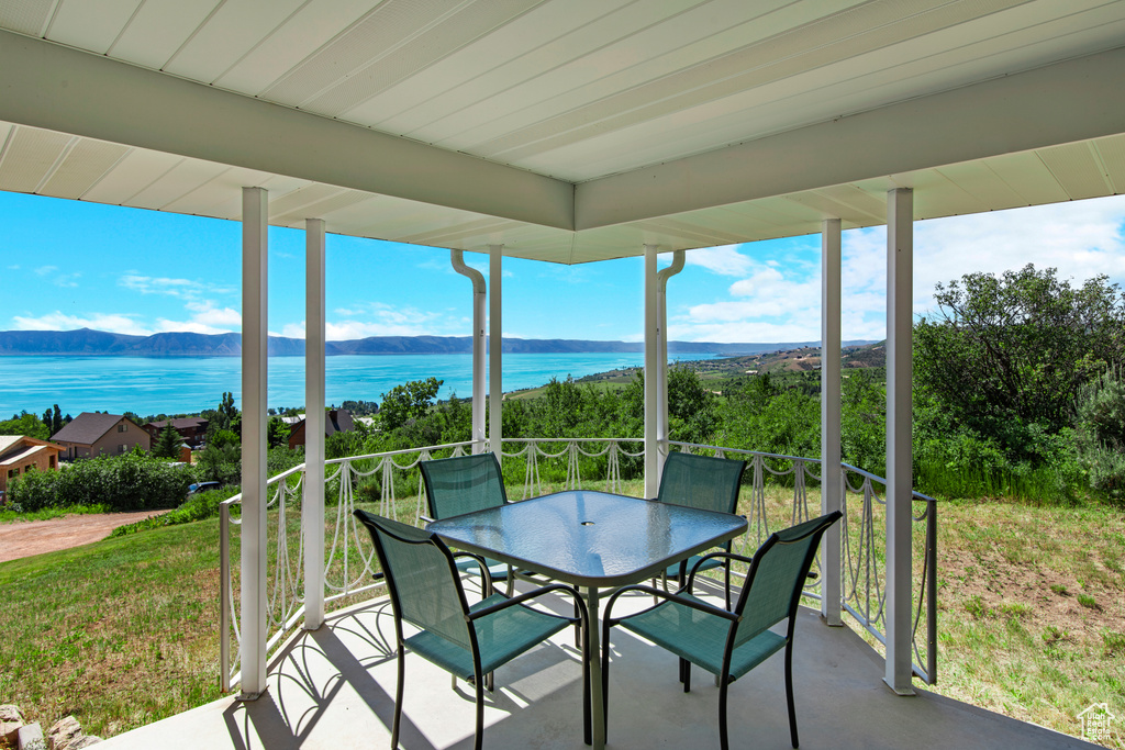 Sunroom with a water and mountain view and outdoor dining space