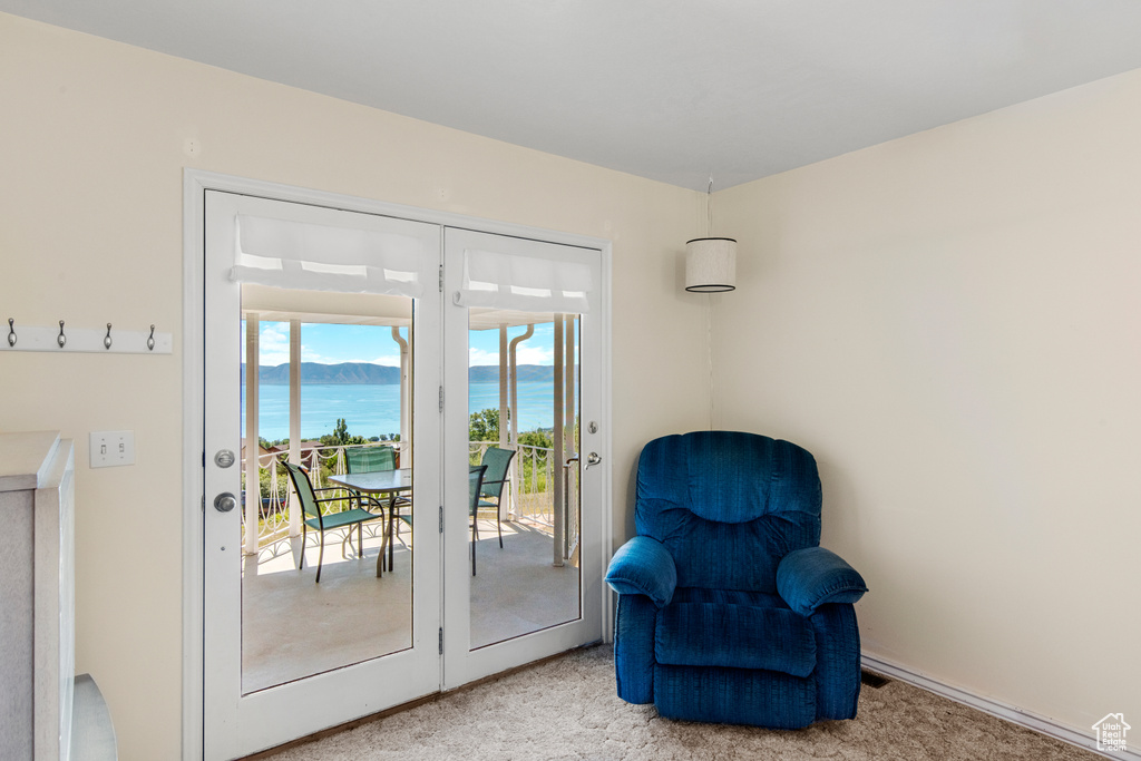 Sitting room featuring a water view and light colored carpet