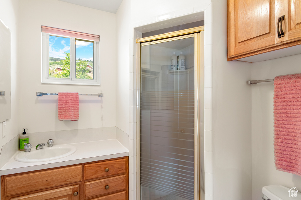 Full bath with a stall shower, toilet, and vanity