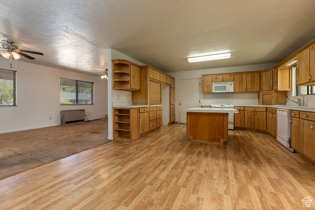 Kitchen with white appliances, open shelves, open floor plan, and light wood-style flooring
