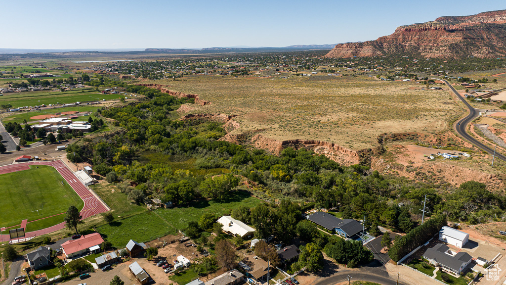 Aerial view of property and surrounding area featuring a mountain backdrop