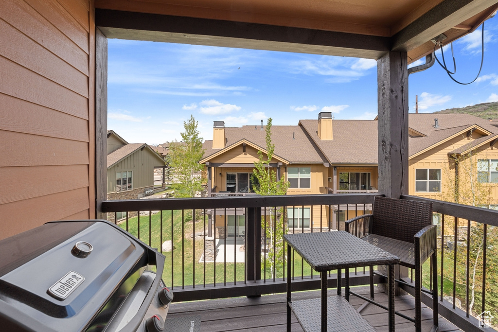 Wooden terrace featuring a residential view and area for grilling