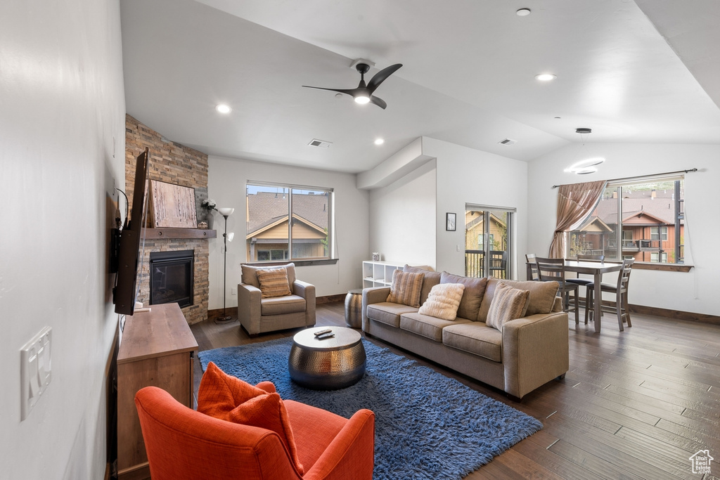 Living area featuring healthy amount of natural light, ceiling fan, vaulted ceiling, wood finished floors, and a fireplace