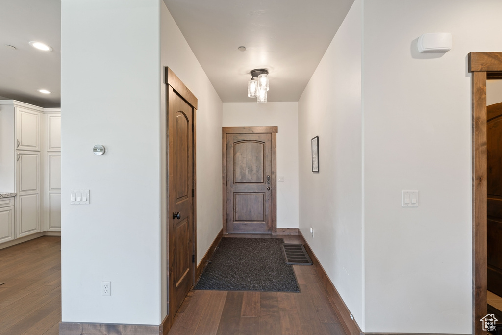Doorway to outside with dark wood-type flooring, recessed lighting, and baseboards