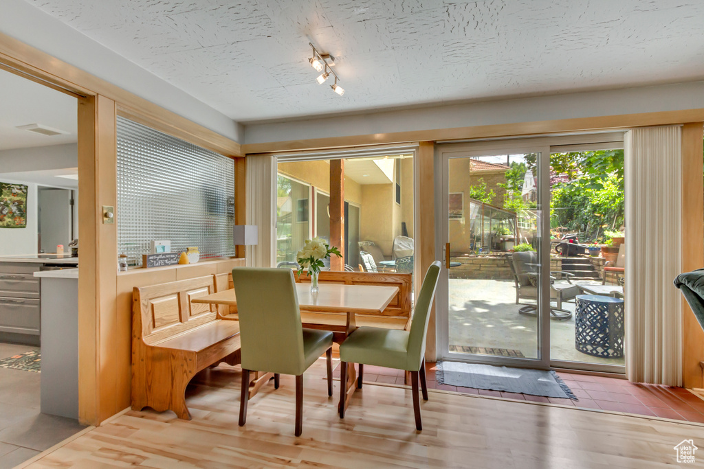 Dining space with track lighting and wood finished floors