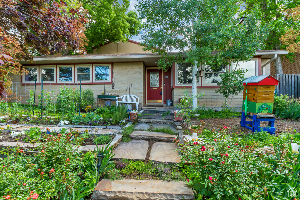 View of front facade featuring brick siding and a vegetable garden