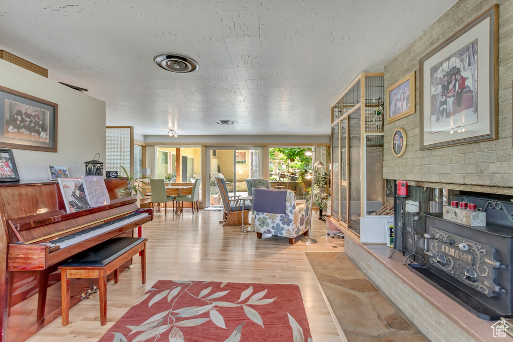 Living area with wood finished floors, a fireplace, and a textured ceiling