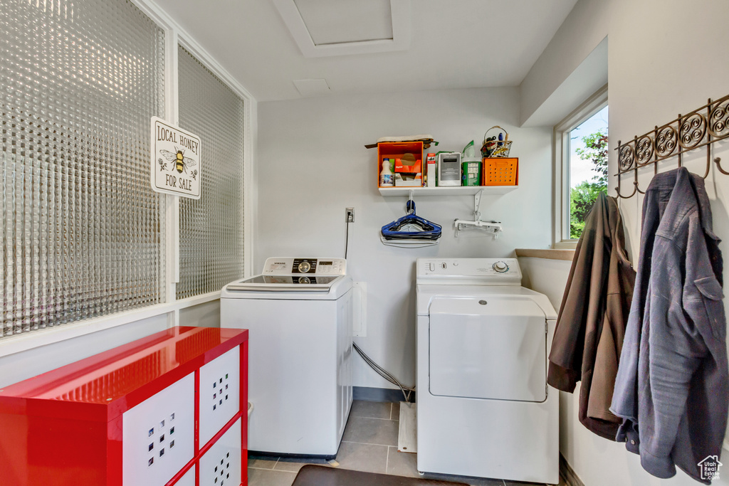 Laundry room featuring washer and dryer, tile patterned floors, and attic access