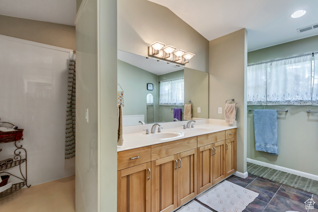 Bathroom featuring double vanity and baseboards