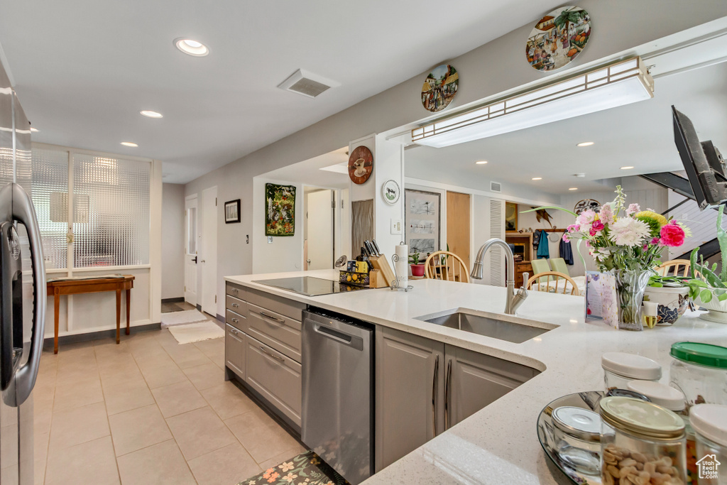 Kitchen with a sink, stainless steel appliances, recessed lighting, gray cabinetry, and light tile patterned floors