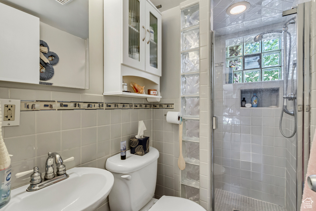 Bathroom with a sink, a shower stall, and toilet
