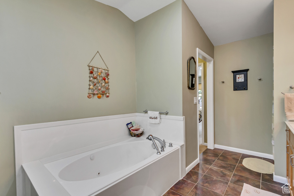 Full bathroom with a garden tub, baseboards, vanity, and tile patterned flooring