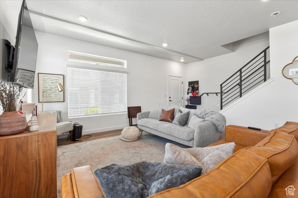 Living area featuring wood finished floors, stairway, recessed lighting, and baseboards
