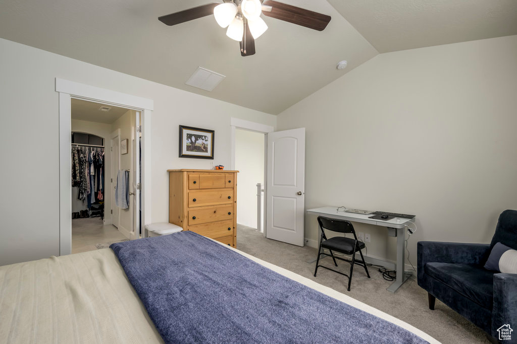 Carpeted bedroom featuring vaulted ceiling, a spacious closet, ceiling fan, and baseboards