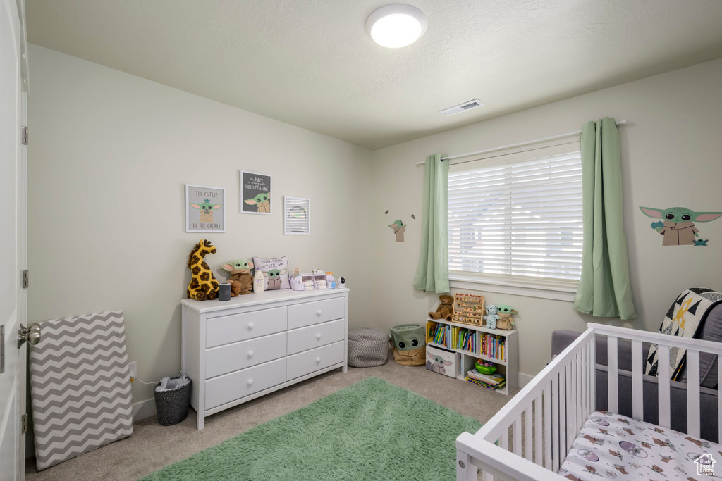 Bedroom with a crib and carpet floors