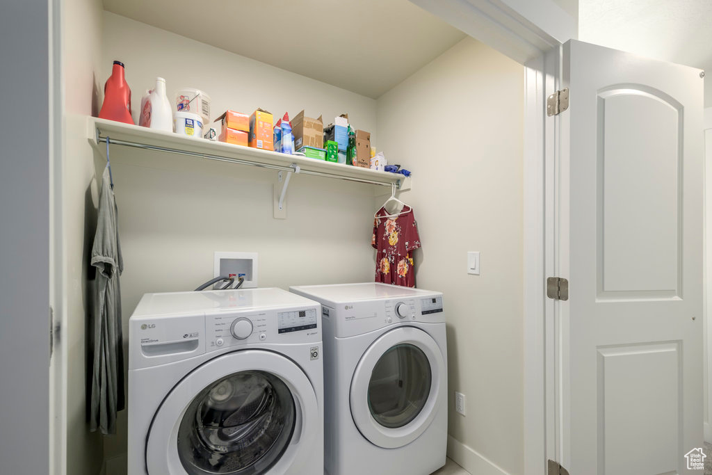 Laundry area with washer and clothes dryer and baseboards