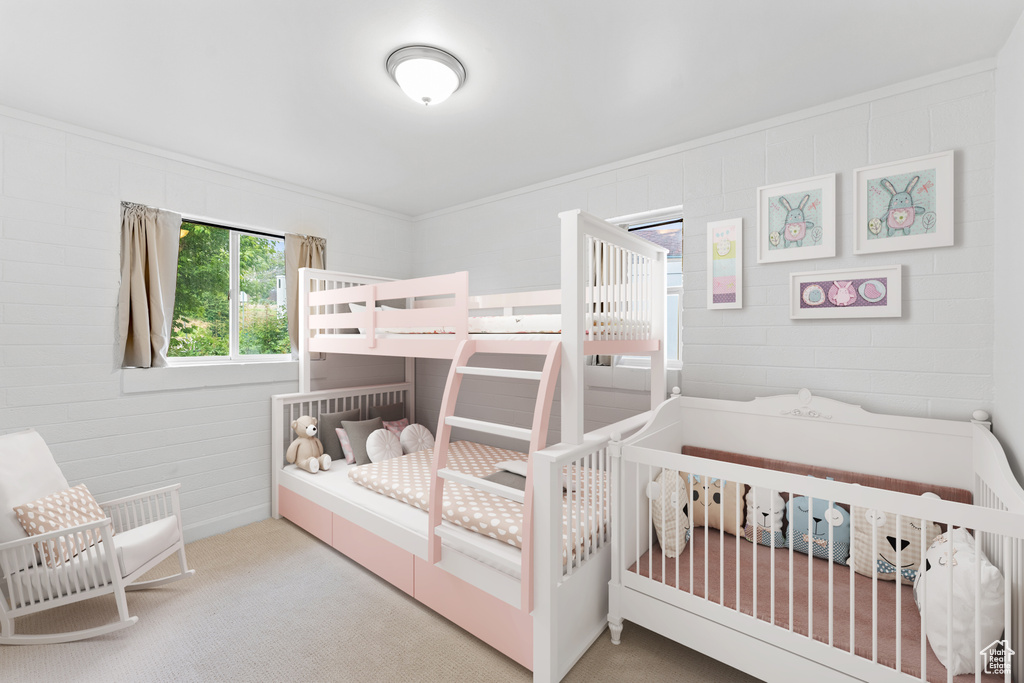 Bedroom with carpet floors, crown molding, and a crib