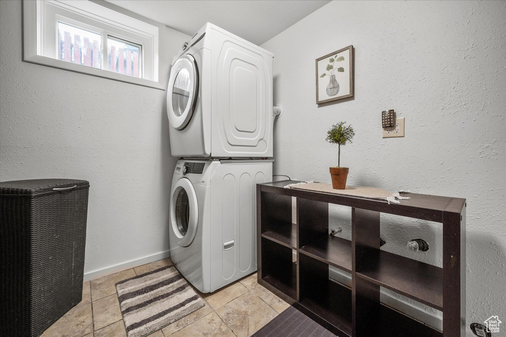 Washroom featuring estacked washer and dryer and light tile patterned floors