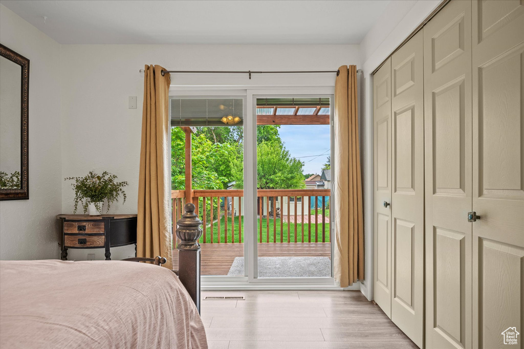 Bedroom with access to outside, light wood-style flooring, and a closet
