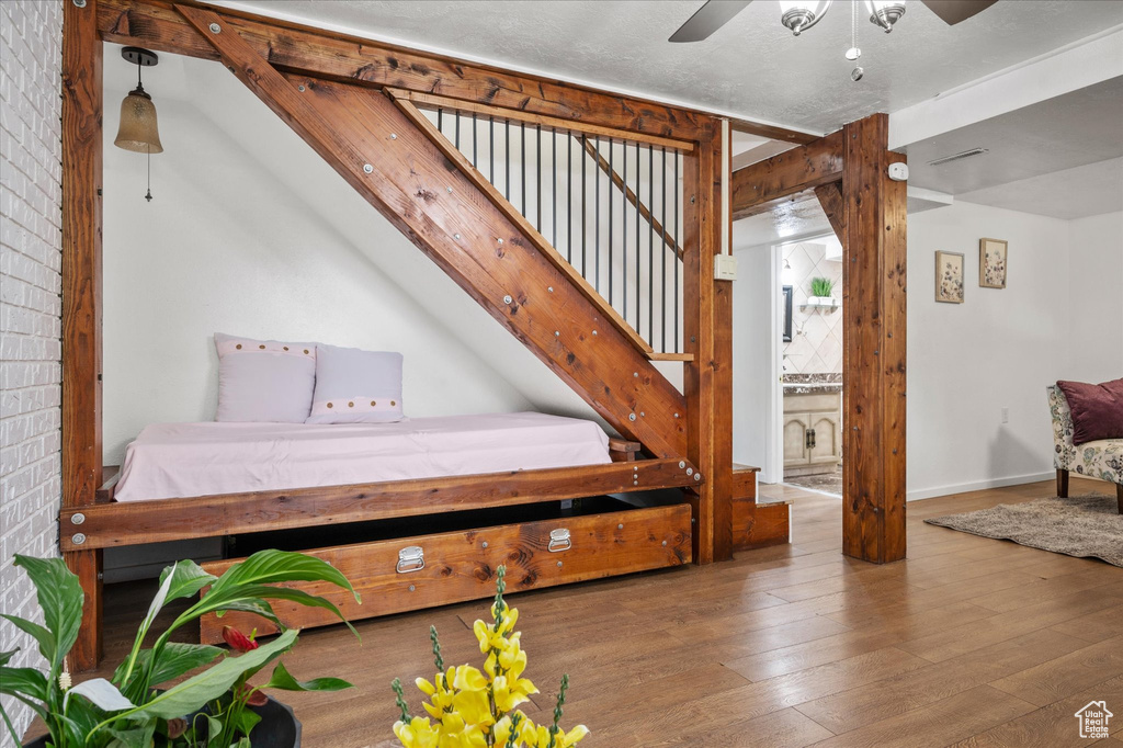 Stairway featuring a ceiling fan, hardwood / wood-style floors, and baseboards