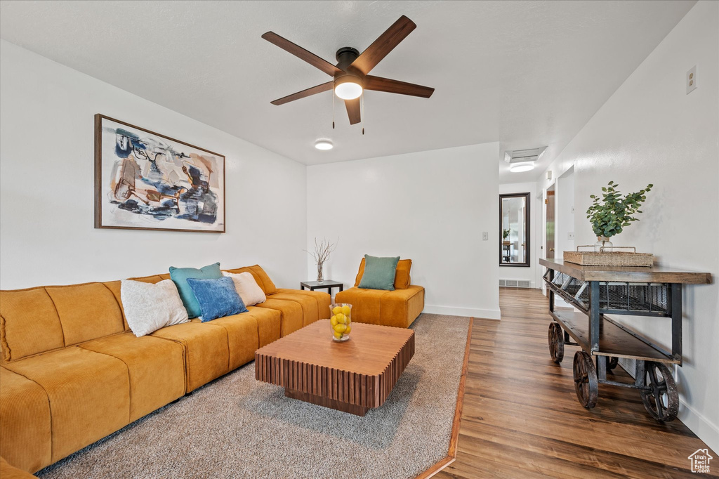 Living room featuring wood finished floors, a ceiling fan, and baseboards