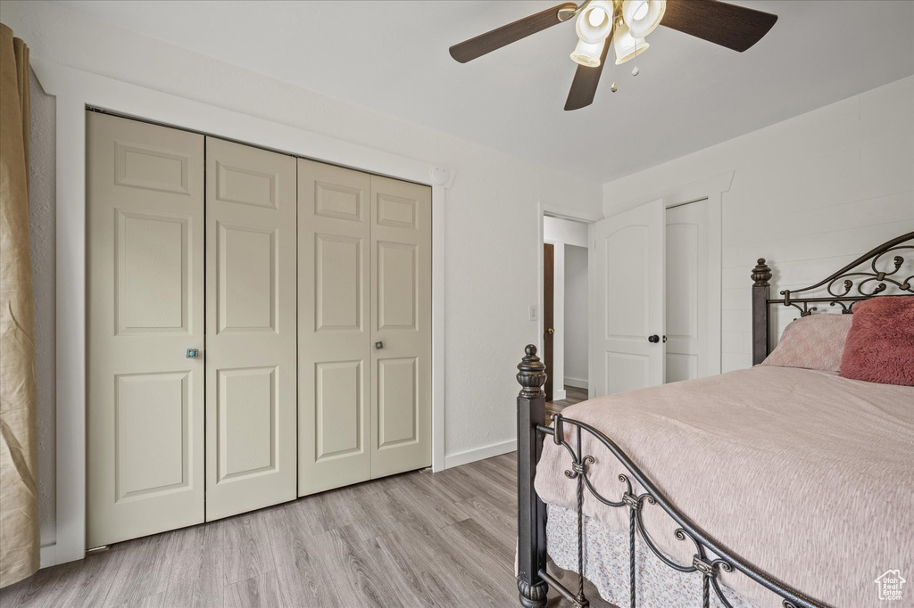 Bedroom featuring light wood-style floors, a ceiling fan, a closet, and baseboards