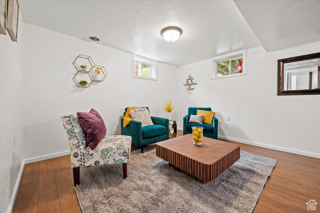 Living area featuring wood finished floors, baseboards, and a textured ceiling