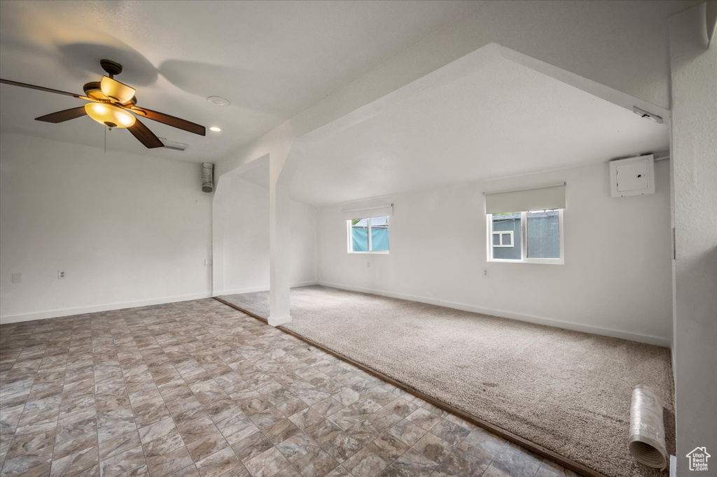 Unfurnished room with ceiling fan, baseboards, carpet, and stone finish flooring