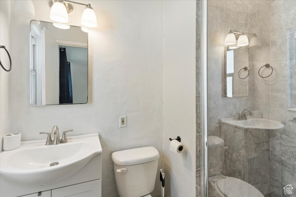 Full bathroom with toilet, a stall shower, and vanity