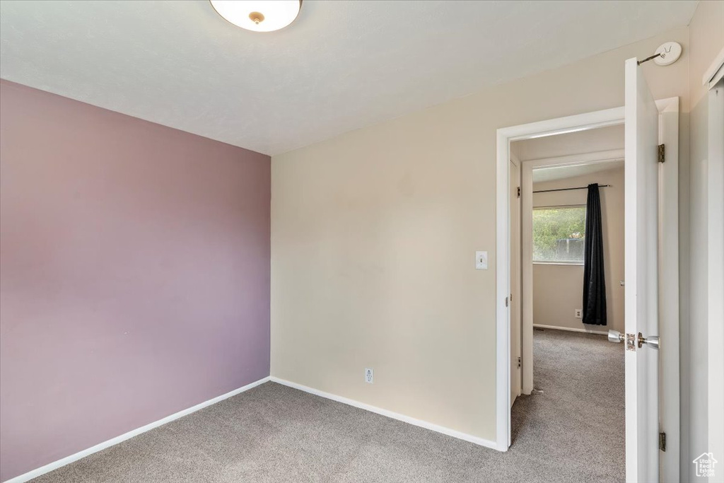 Empty room featuring carpet and baseboards