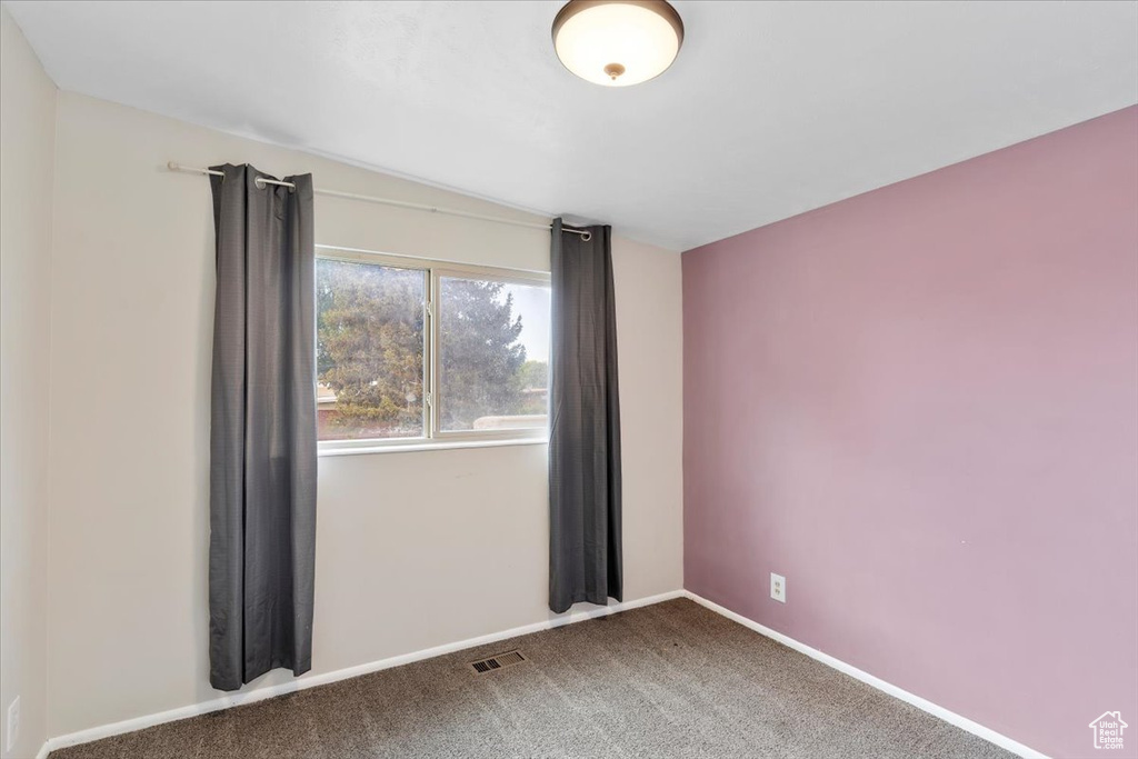 Carpeted spare room with baseboards