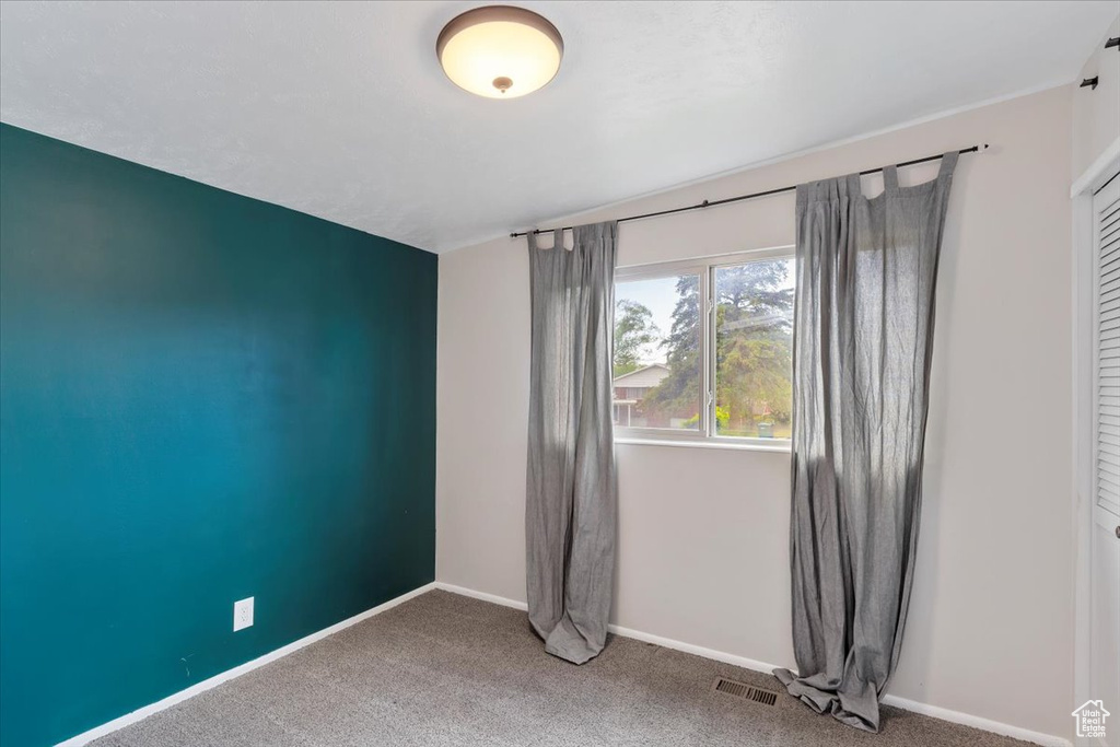 Carpeted empty room featuring baseboards