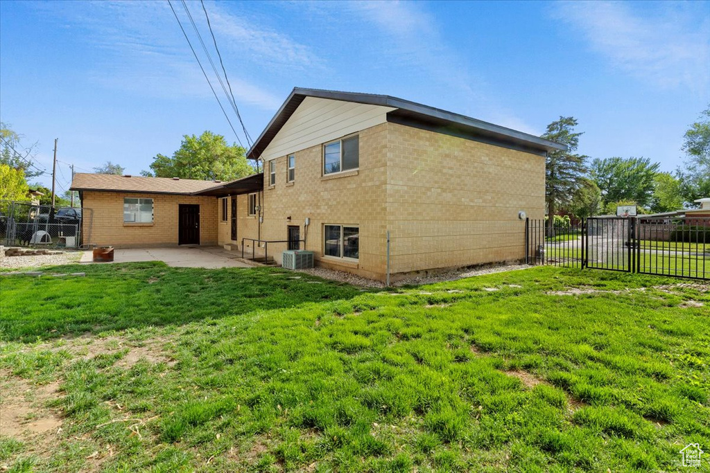 Rear view of property featuring a patio area, brick siding, and central AC unit