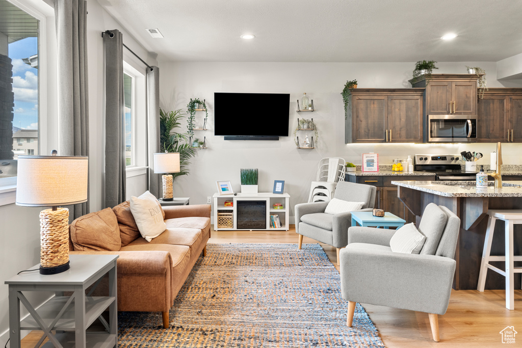 Living room with light wood-style floors and recessed lighting