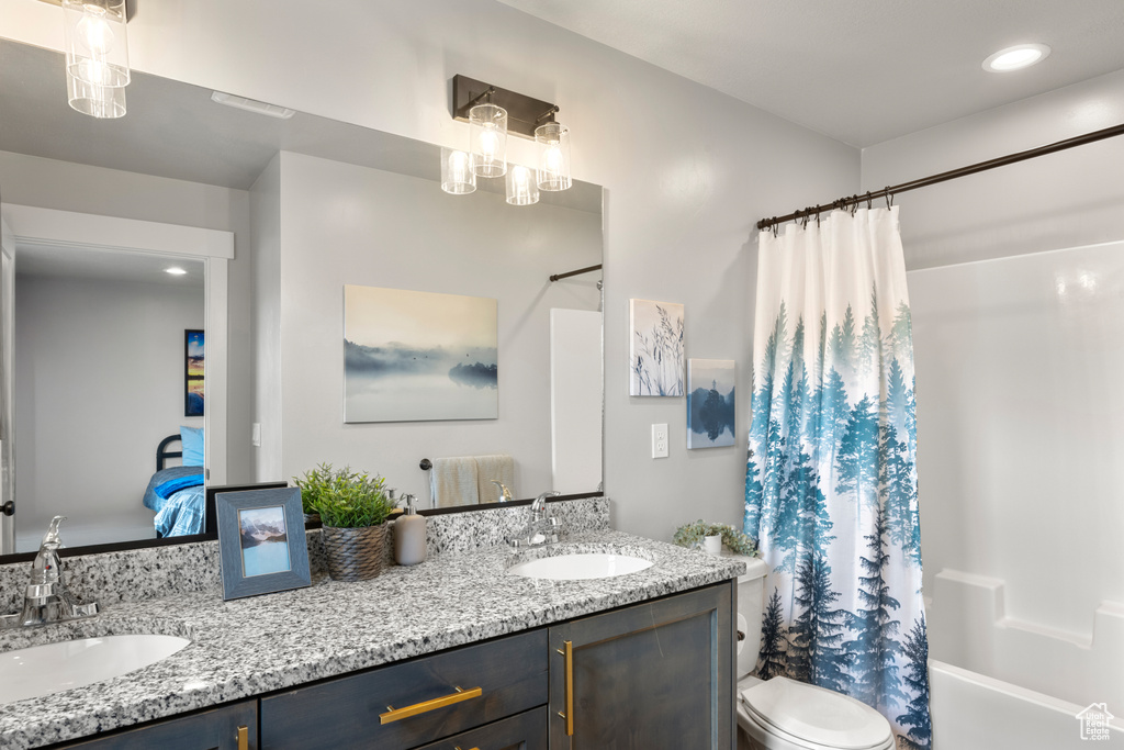 Full bathroom featuring toilet, double vanity, shower / bathtub combination with curtain, and recessed lighting