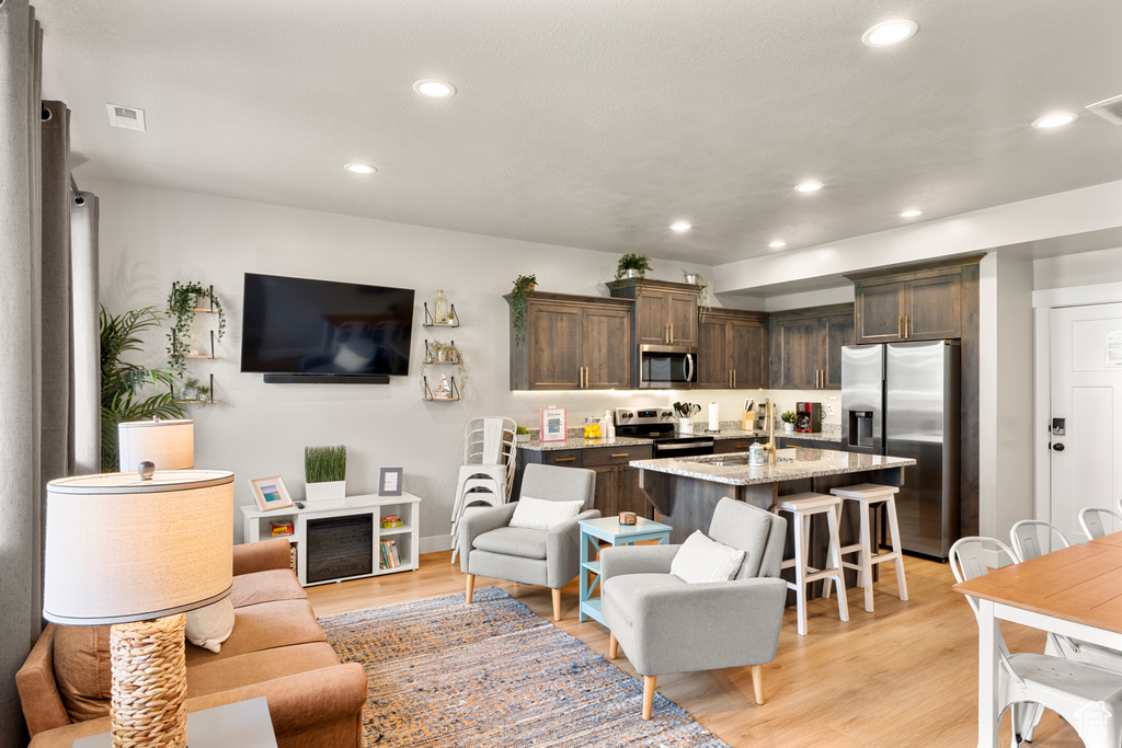 Living room featuring light wood-type flooring, recessed lighting, and baseboards