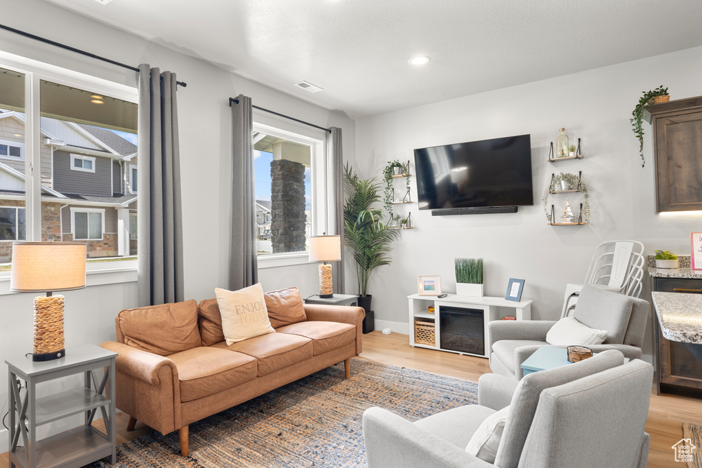Living area featuring light wood-style flooring and recessed lighting
