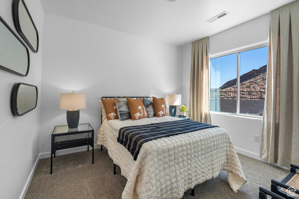 Bedroom with carpet, baseboards, and a mountain view