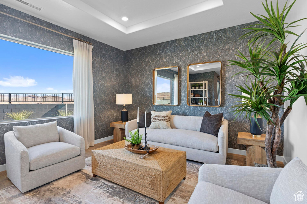 Living room with baseboards, a tray ceiling, and recessed lighting