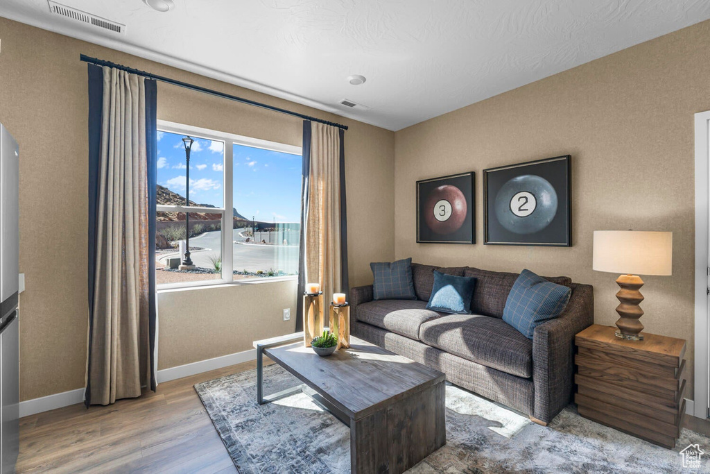 Living area featuring plenty of natural light, wood finished floors, and baseboards