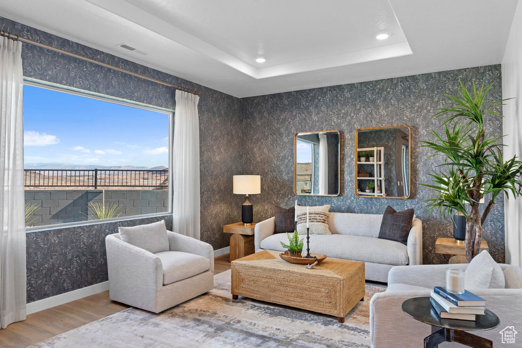 Living area with wood finished floors, recessed lighting, and a raised ceiling