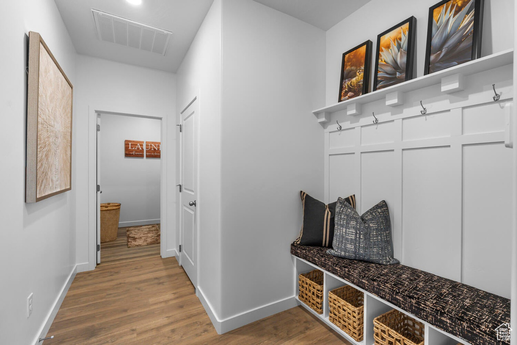Mudroom with wood finished floors and baseboards