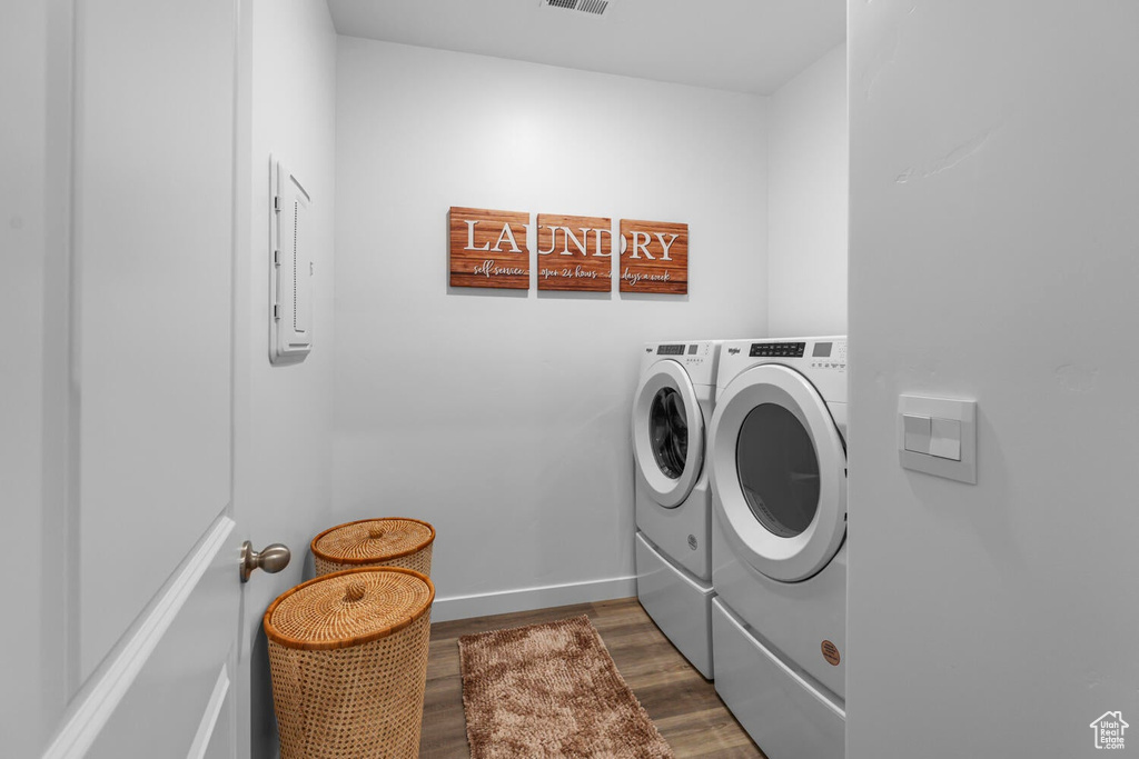 Laundry area with washer and clothes dryer, dark wood-type flooring, and baseboards